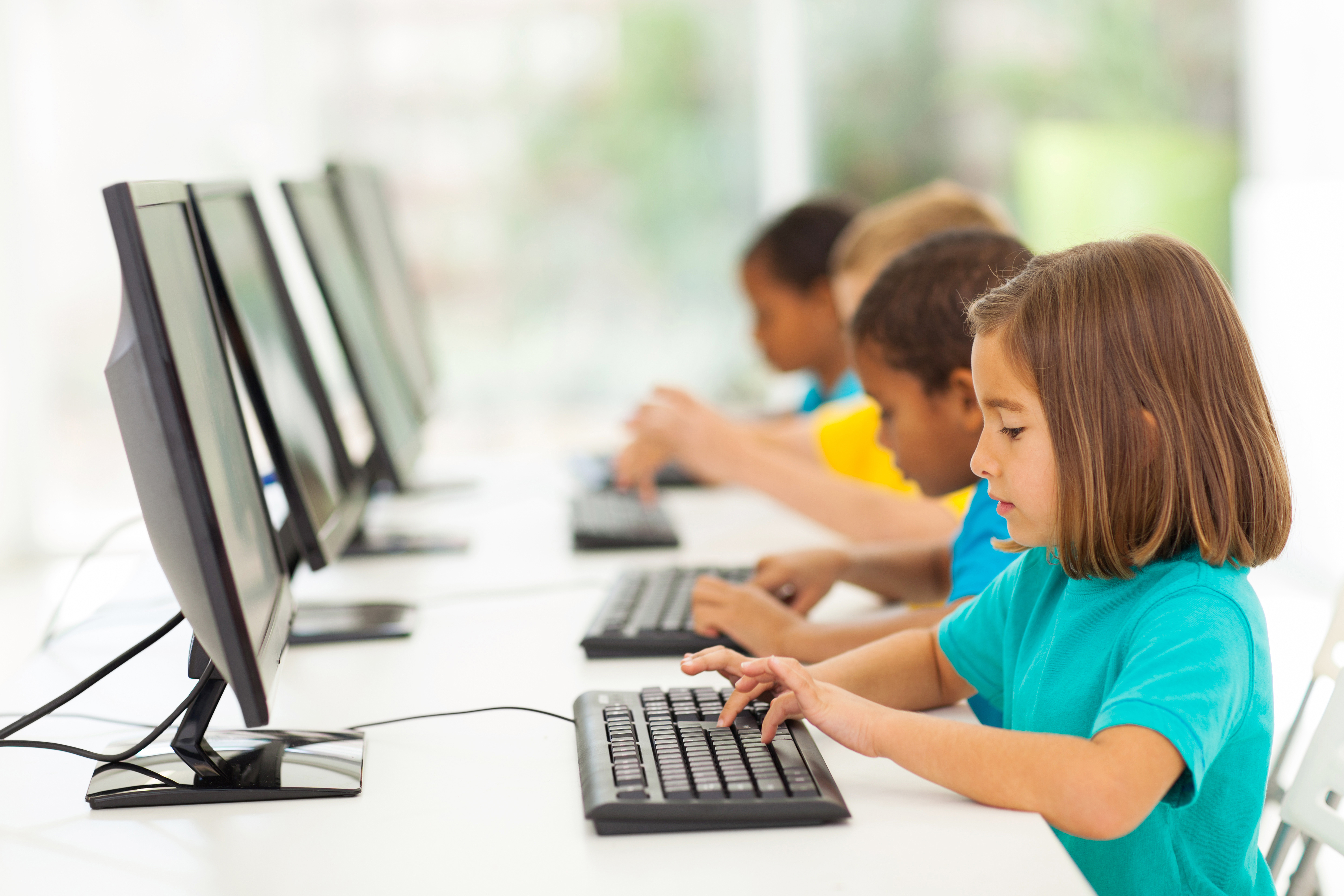 An image of young students using desktop computers