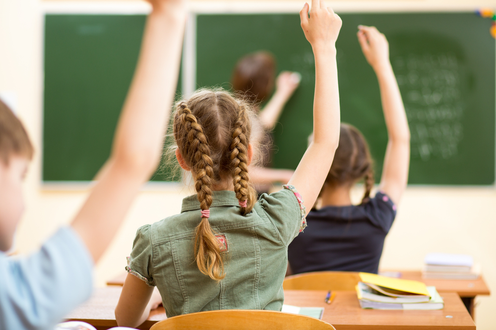 kids in classroom hands raised