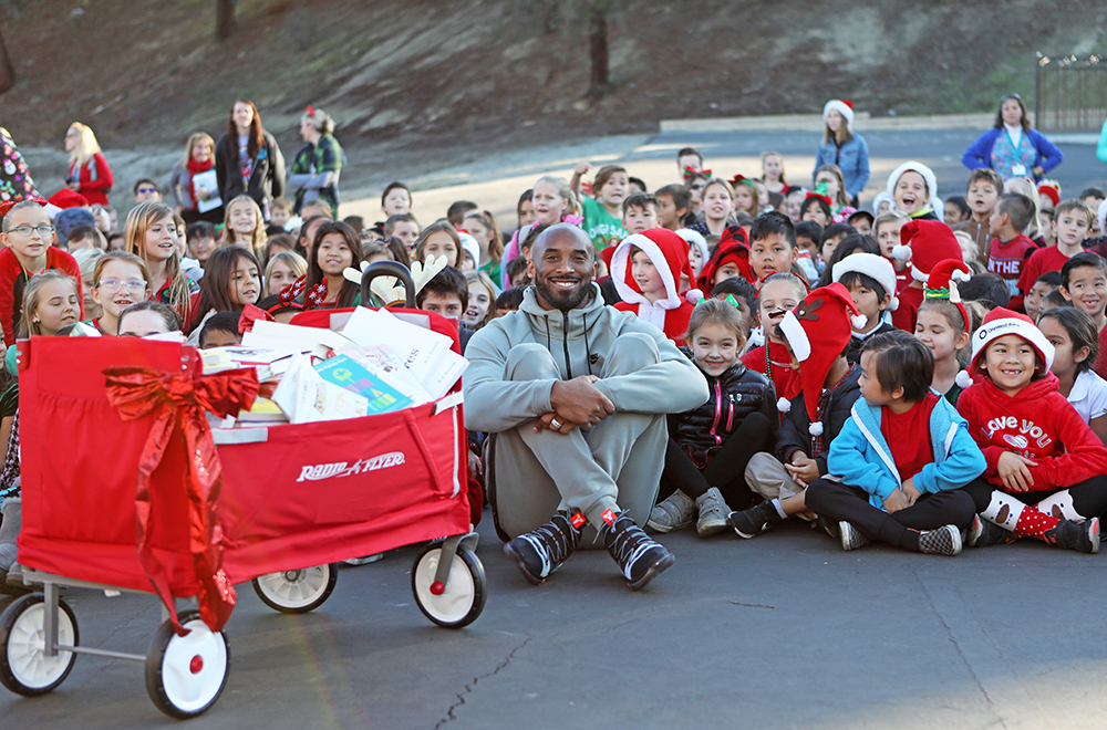 Kobe poses with students and books