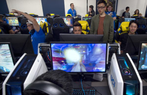 students gather around computer monitors to play video games
