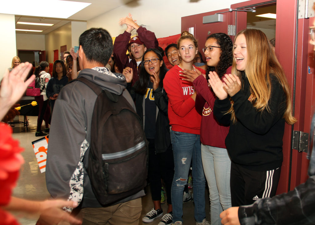 Students cheer a senior on campus