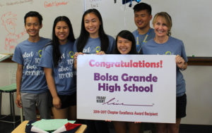 Students from Friday Night Live program hold congratulatory signs