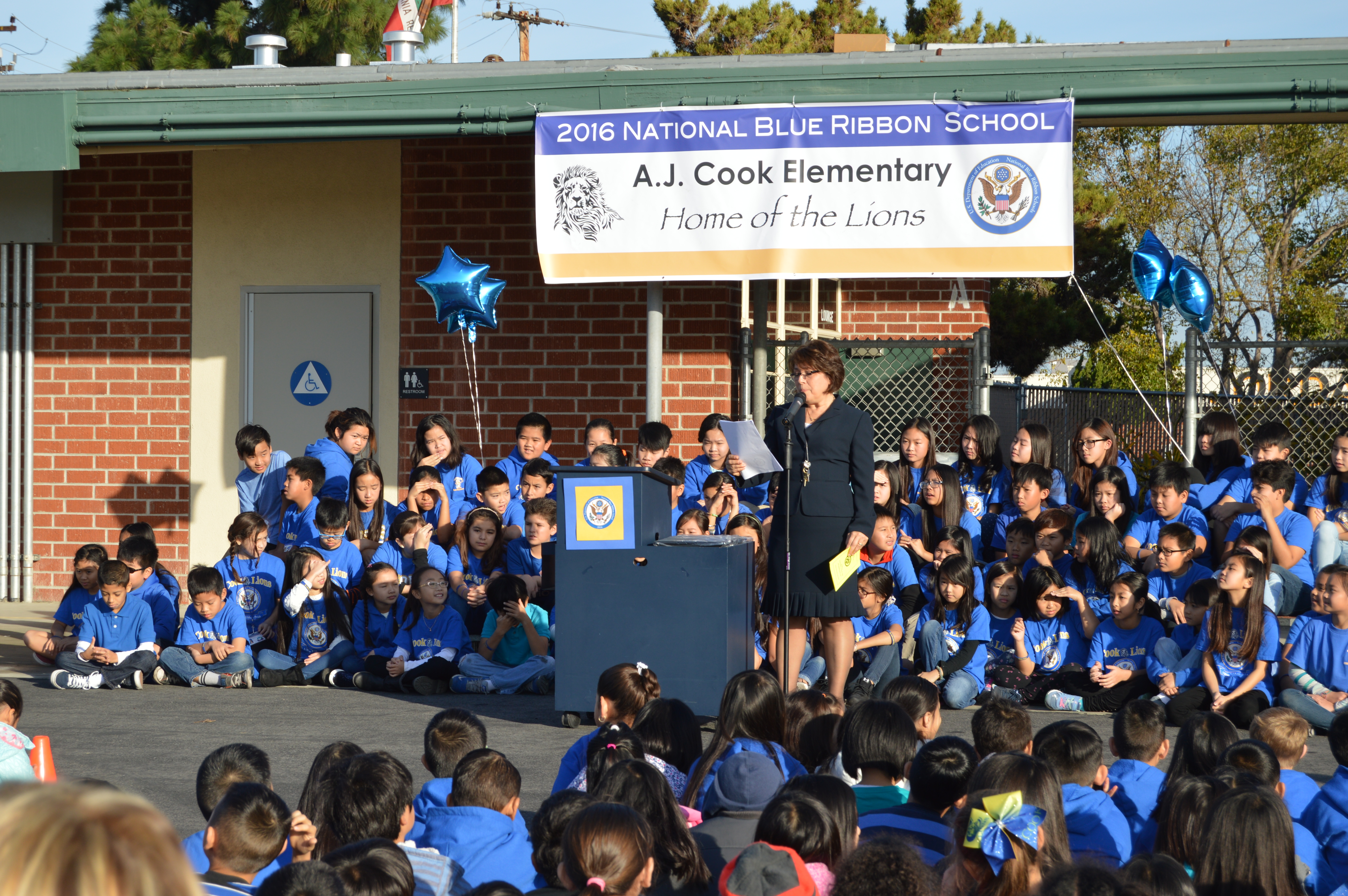 The principal of Cook Elementary School leads an outdoor assembly