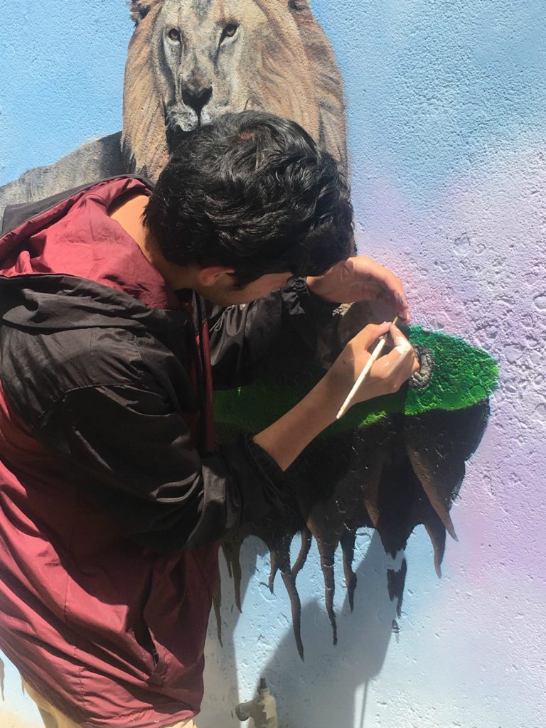 Student painting part of a mural