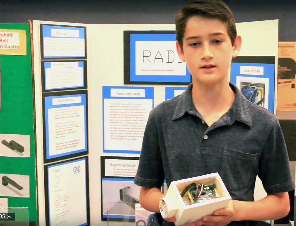 A student holds his project during the ocMaker Challenge