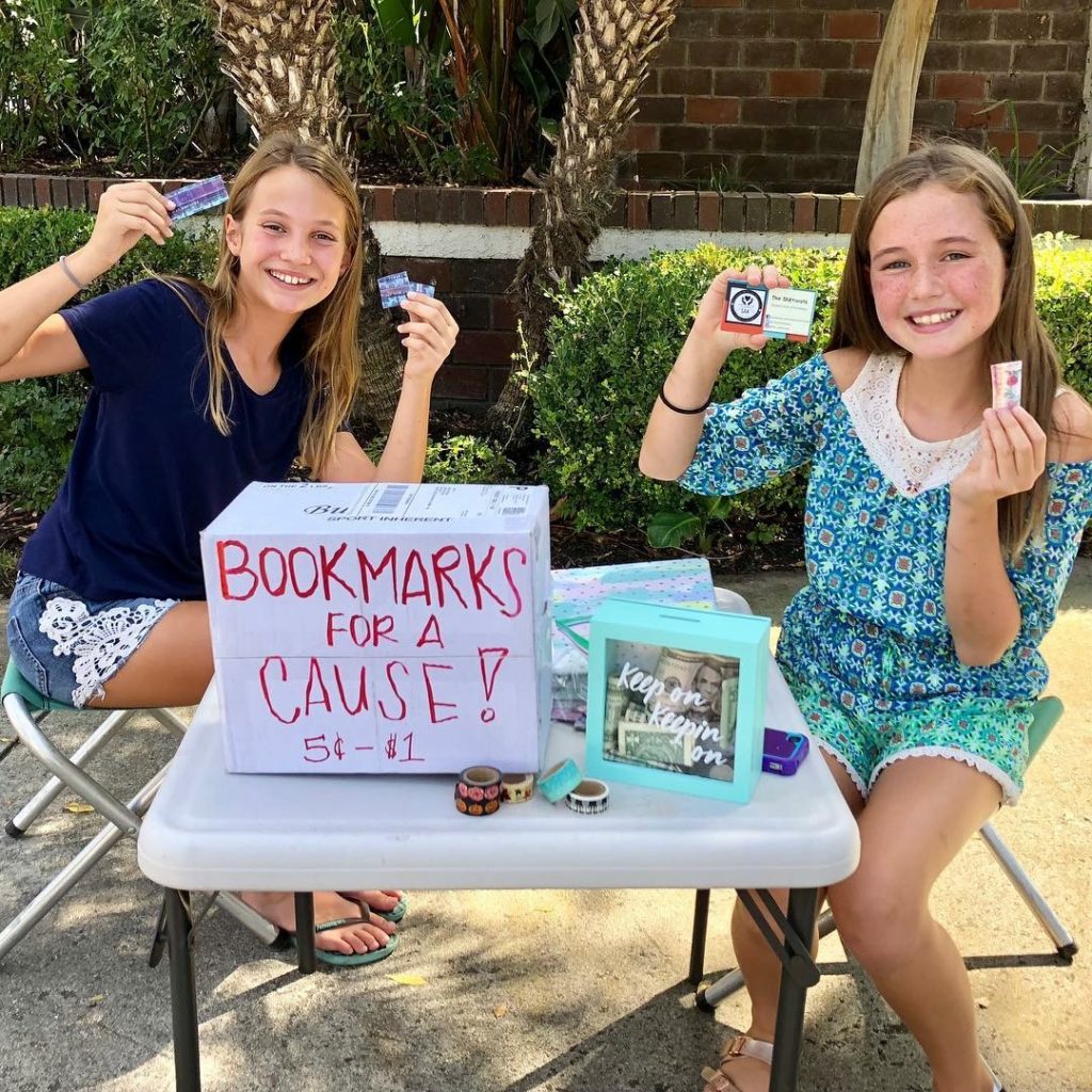 Two students selling bookmarks outside