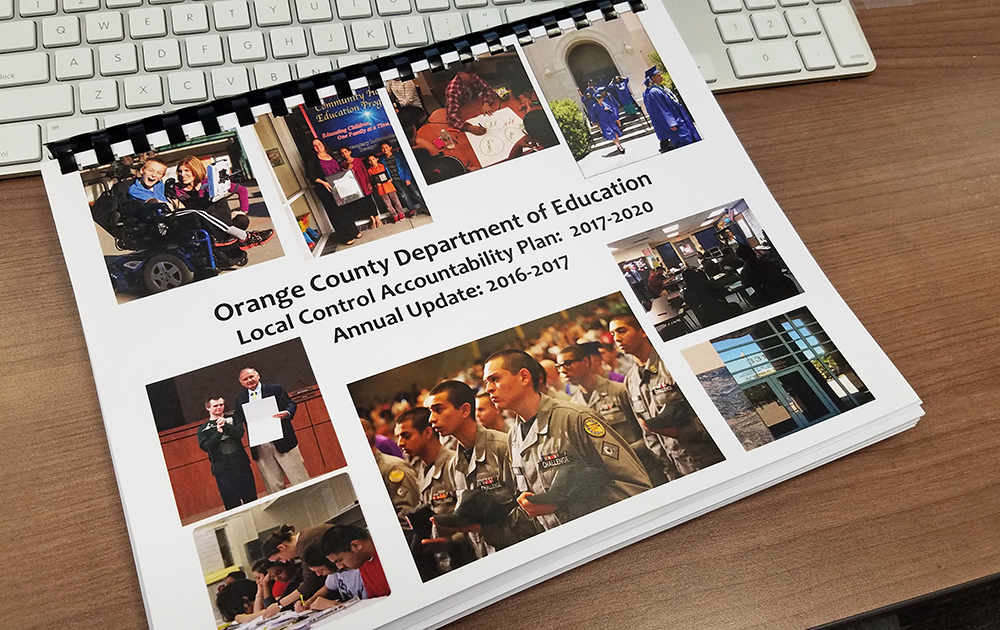 A hard copy of Orange County Department of Education's Local Control Accountability Plan sits on a desk.
