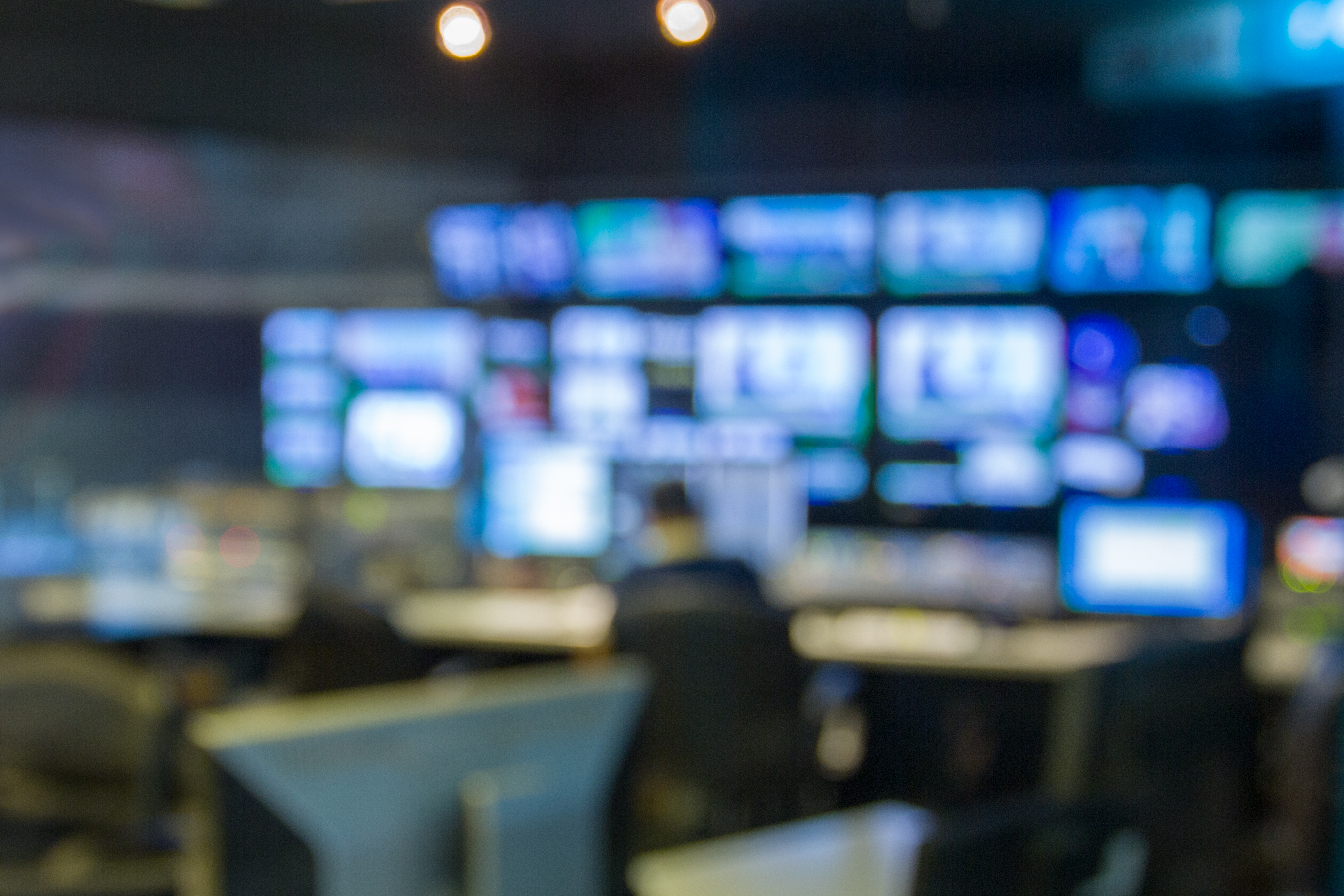 A blurred image of a broadcast newsroom
