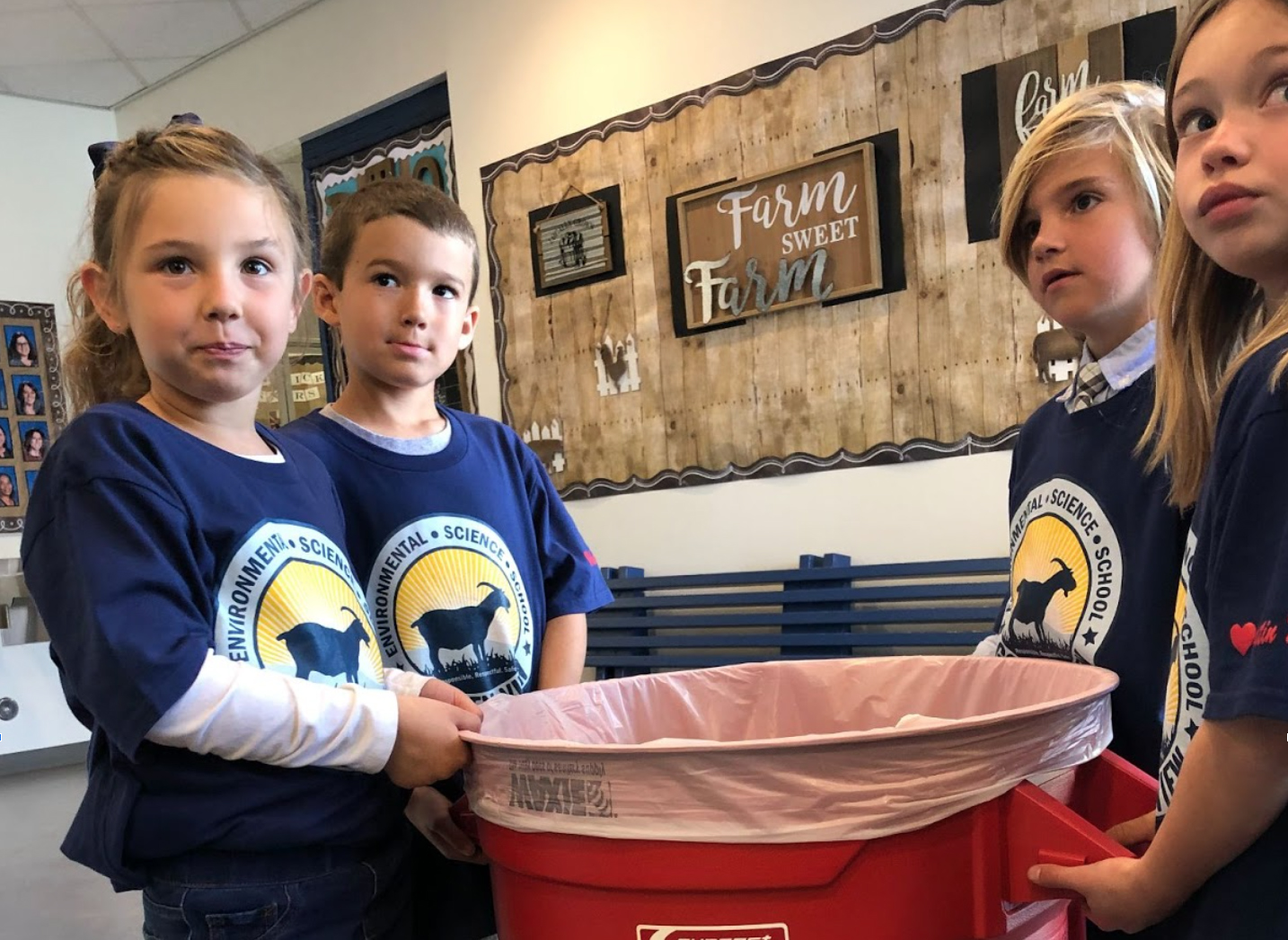Kids holding a recycle bin