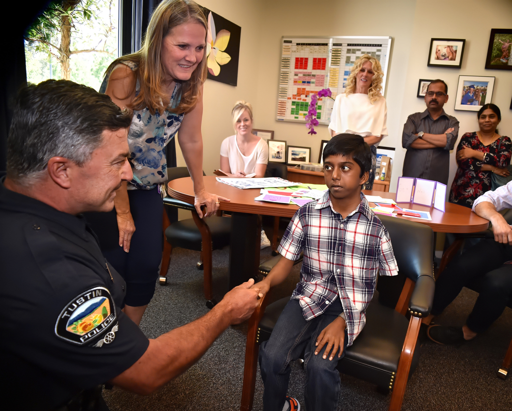 An image of Tustin PD Officer Ralph Casiello and TUSD nurse Pam Atkins greeting 13-year-old Siva Pelluru
