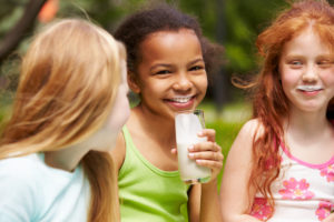 An image of smiling girls drinking milk