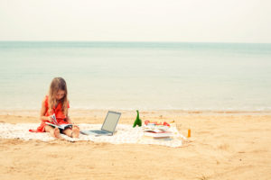 An image of a girl reading at the beach