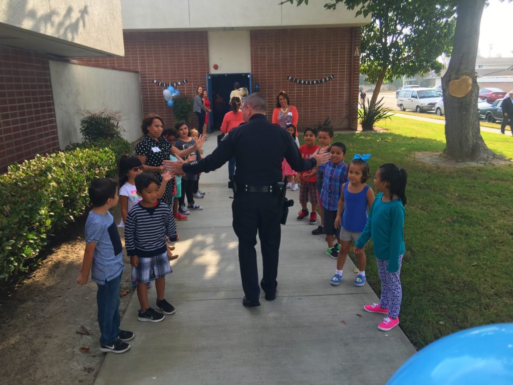 police officer high-fiving students at GGUSD
