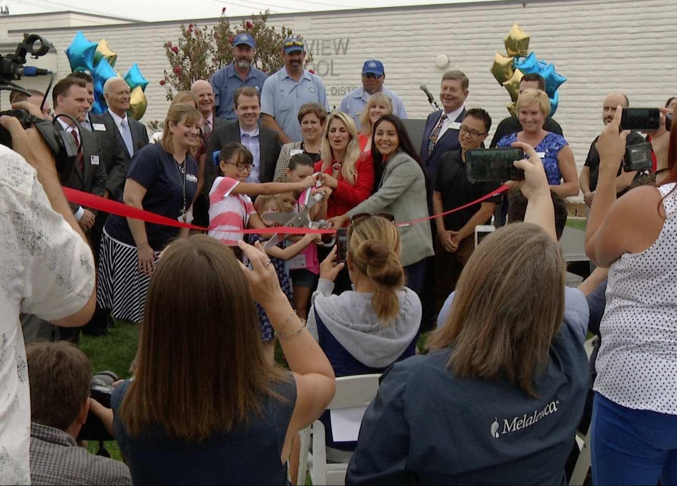 An image showing participants cutting ribbon during the reopening of Lake View Elementary School