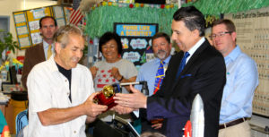 Superintendent Al Mijares passes a Golden Apple award to Jim Blackie of Ensign Intermediate School