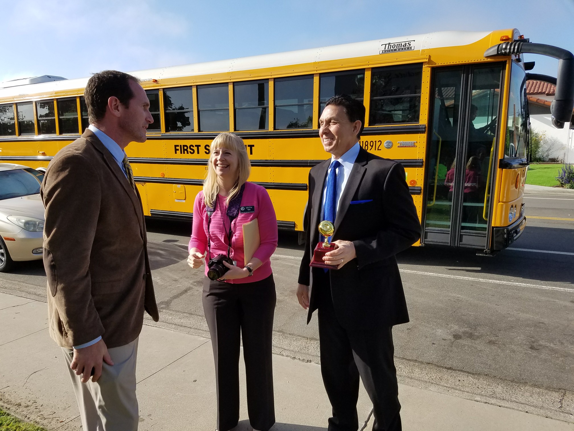 Orange County Superintendent of Schools Dr. Al Mijares and others in front of a school bus