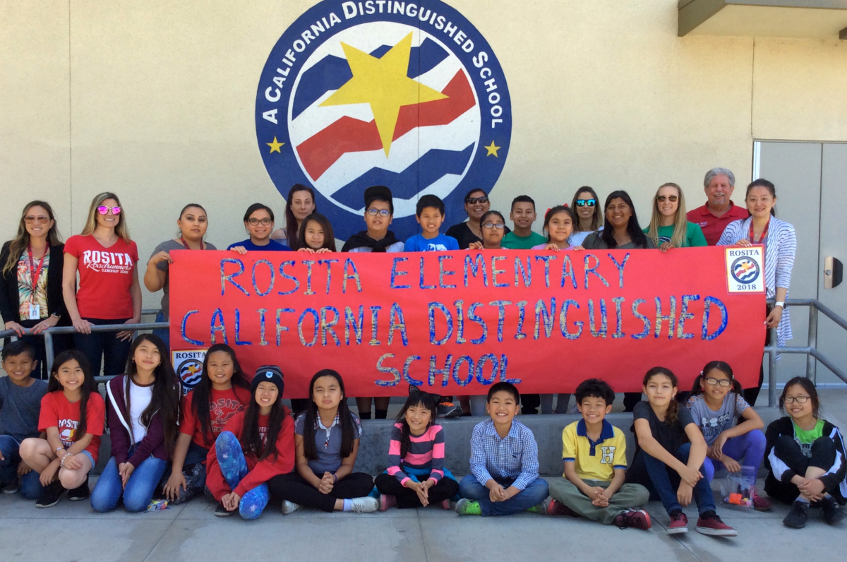 Rosita Elementary students holding a banner in front of the Distinguished Schools banner