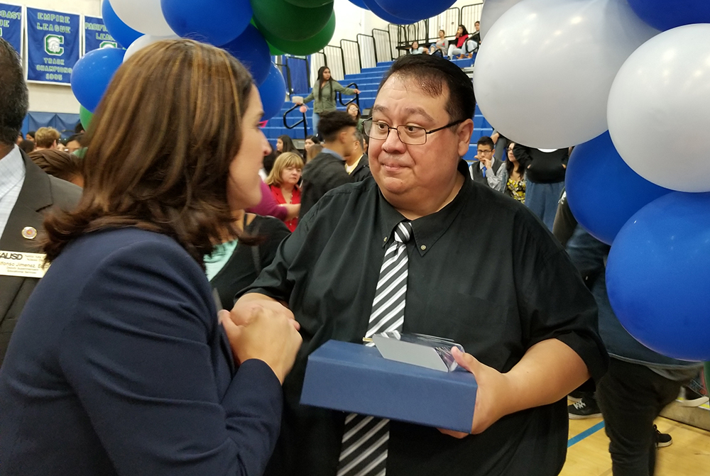 high school counselor receives congratulations at ceremony
