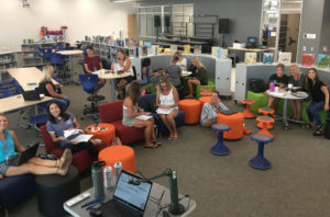 teachers sit inside a library collaborating on lessons