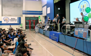 students on stage asking questions via audio stream to astronaut