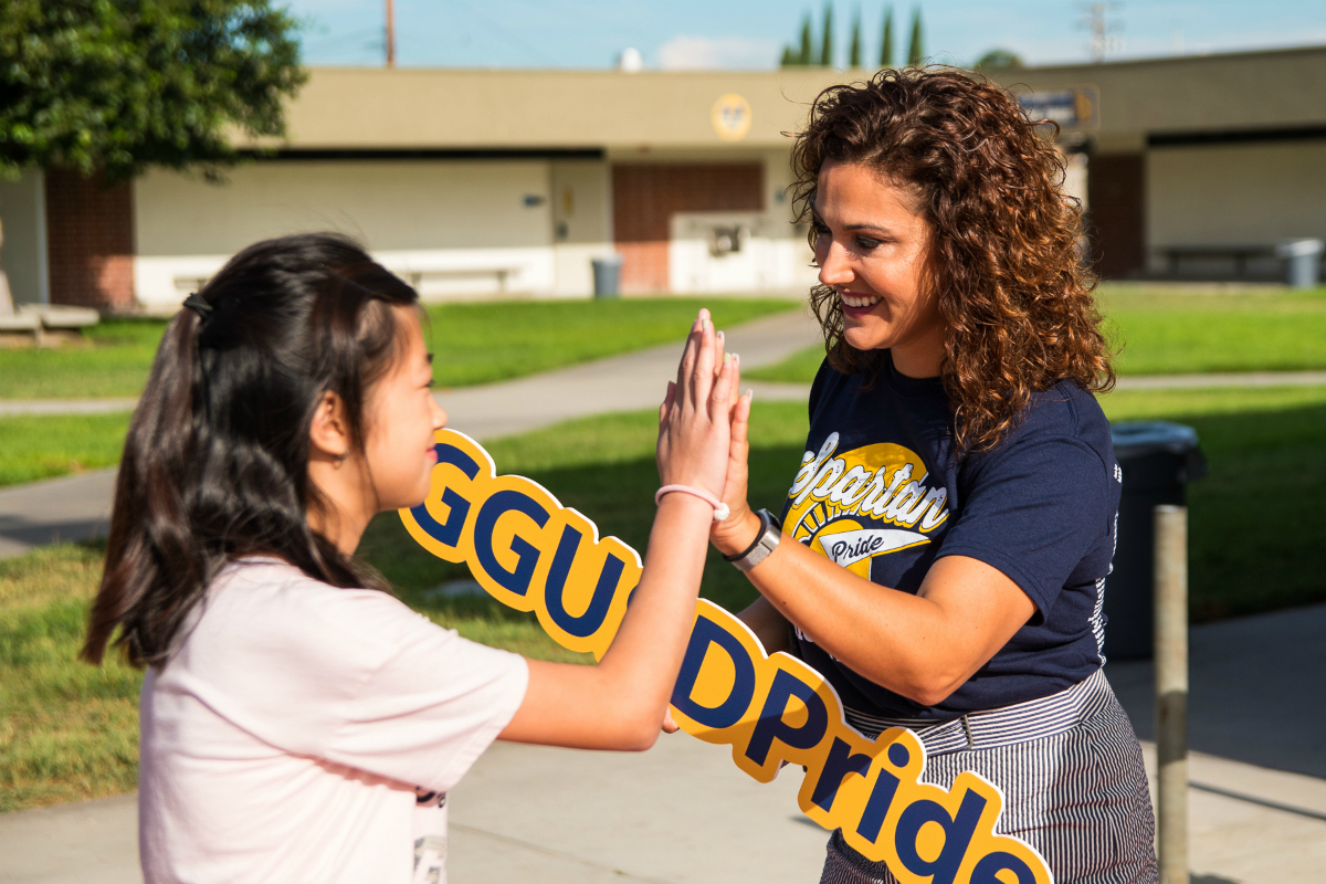 Assistant Principal gives a student a high-five