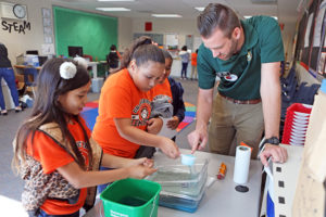 a teacher leads students in science experiment