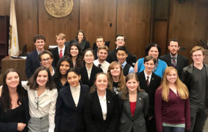 Students pose for photo in a courtroom