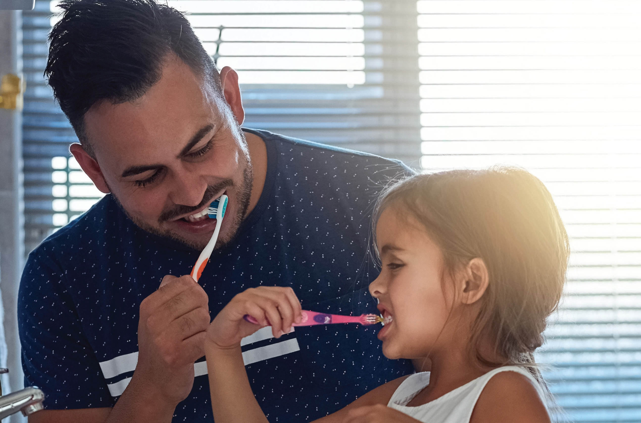 adult and child brushing their teeth