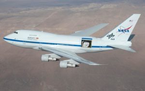 A modified jetliner used for space exploration flies above the ground