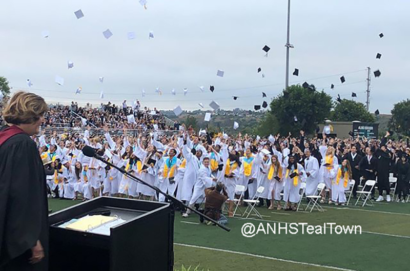 graduating students throw caps in the air