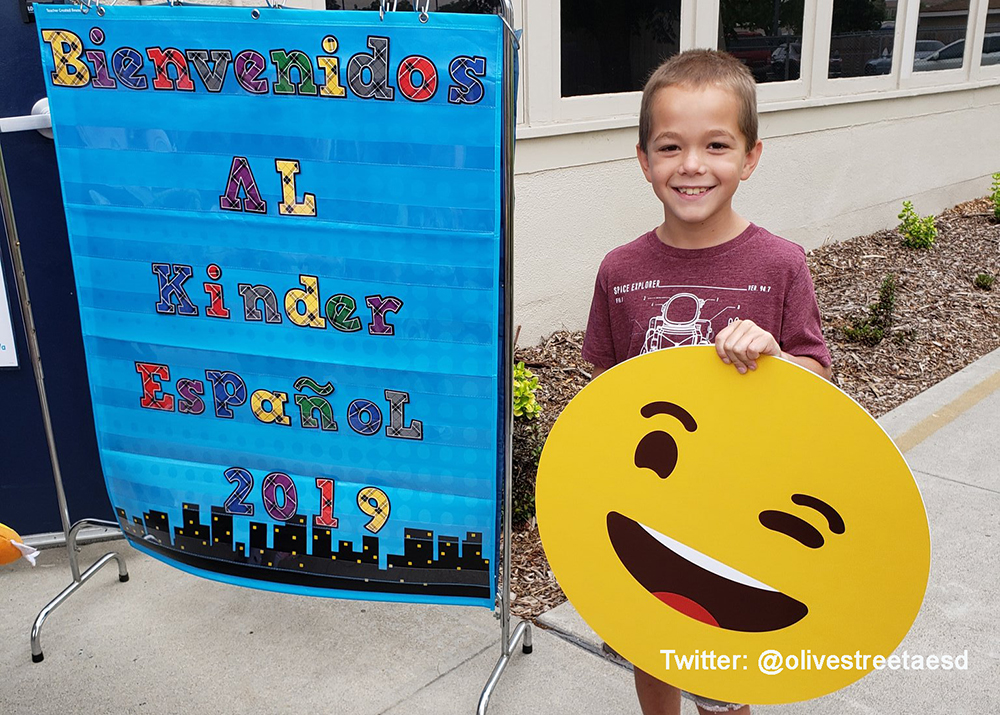 student holds up emoji at school