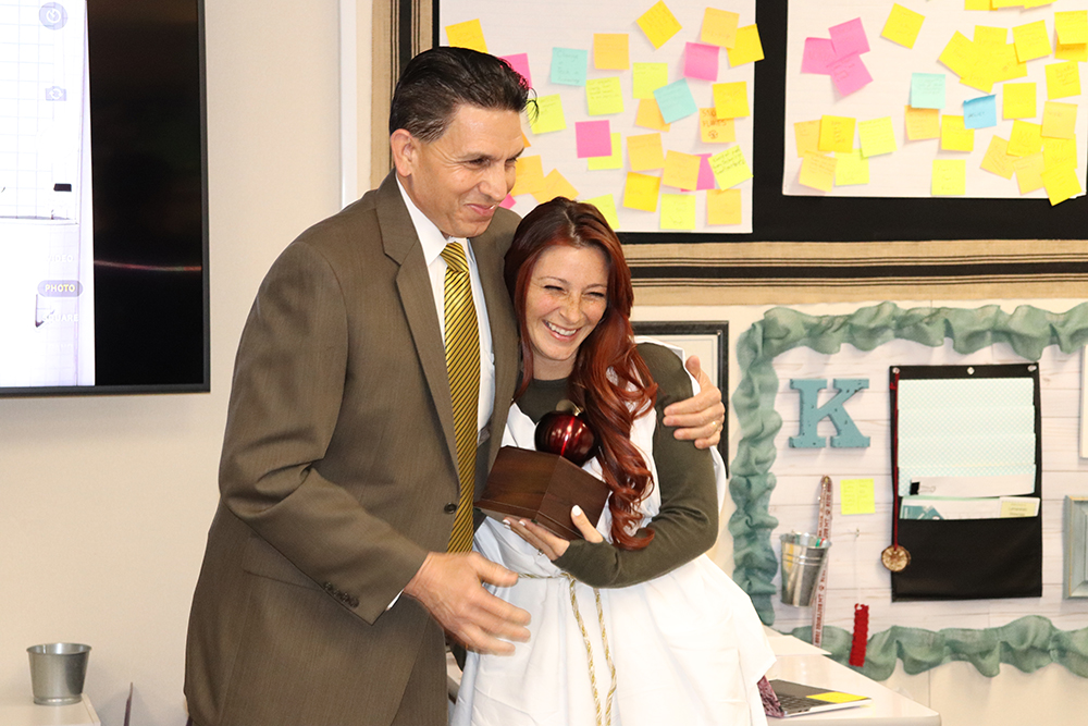 county superintendent hugs a teacher of the year