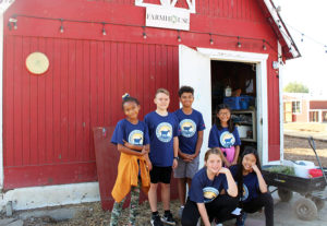 students pose in front of a barn