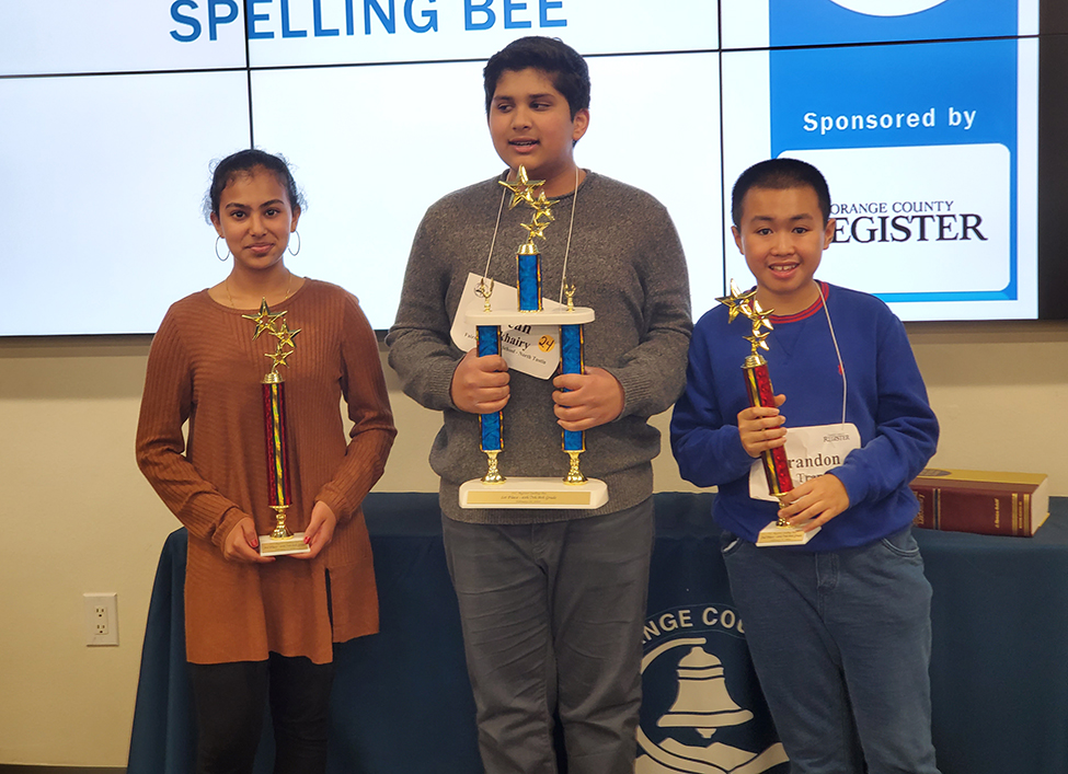 spelling bee students hold trophies