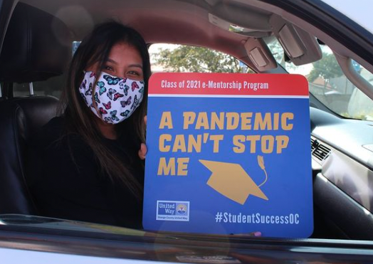 Student in car holding sign that reads, "A pandemic can't stop me"