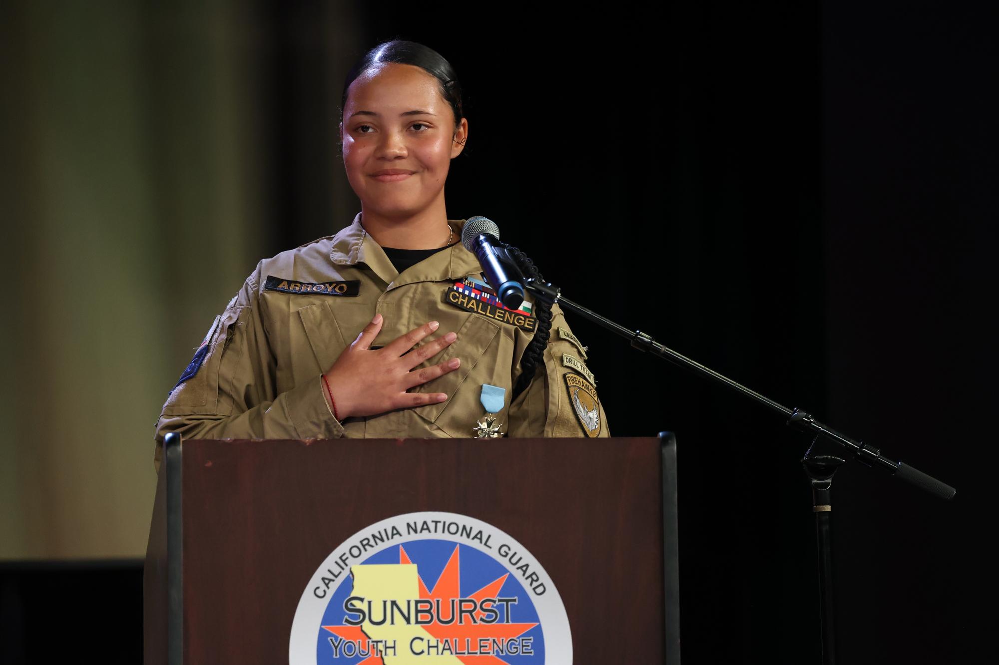 Cadet First Sergeant Issabelle Arroyo stands with her hand over her heart during the Sunburst Youth Academy Class 35 commencement ceremony.