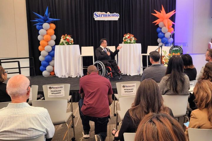 Dr. Stefan Bean addresses an audience from the stage at the Small-Scale Housing Summit in Santa Ana.