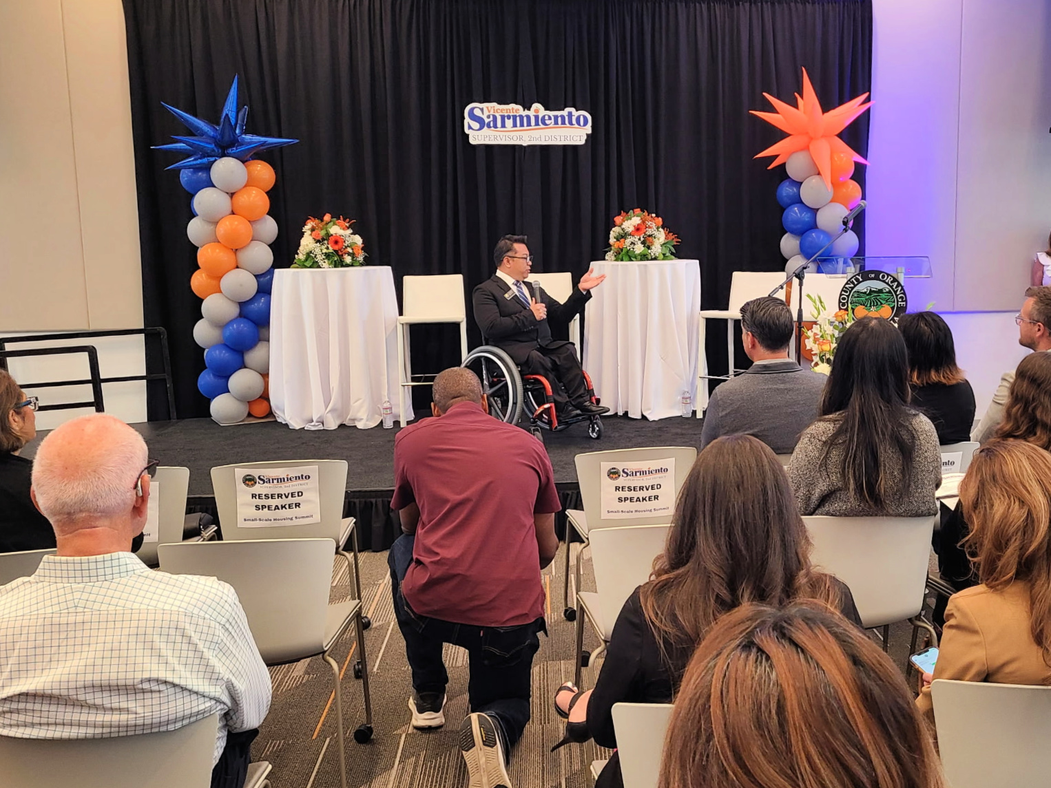 Dr. Stefan Bean addresses an audience from the stage at the Small-Scale Housing Summit in Santa Ana.