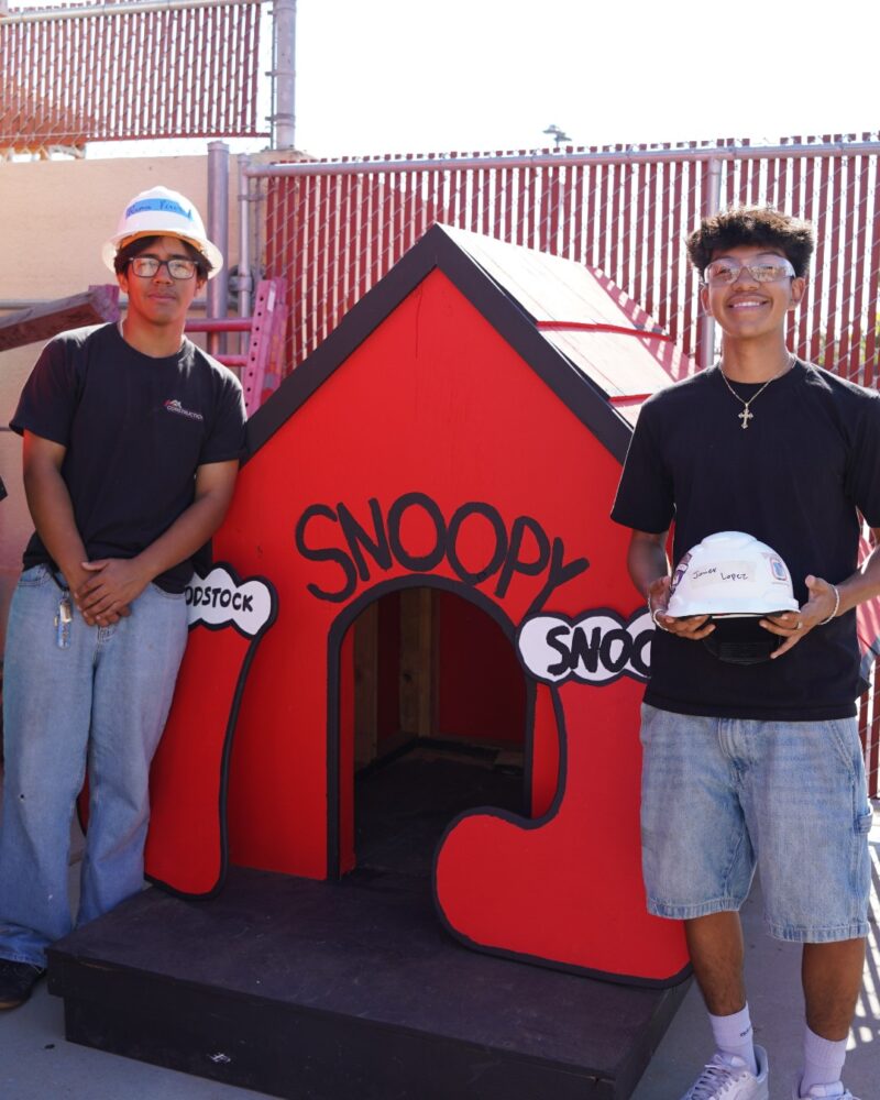 Estancia High School students stand beside a rebuilt Snoopy doghouse they helped construct as part of a project supporting Costa Mesa’s annual Snoopy House display.