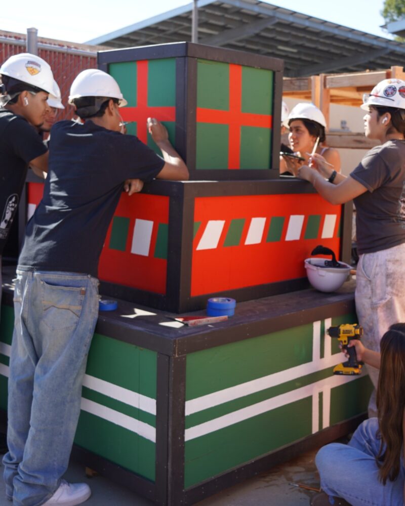 Estancia High School students paint and assemble redesigned holiday present cutouts as part of their work restoring Costa Mesa’s Snoopy House display.
