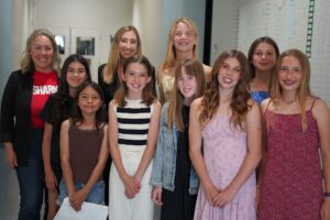 Student speakers from Newport Heights Elementary School pose backstage with school counselor Lauren Smith, back row center, and Principal Terri Clarke, far left, following a TED-Ed Showcase event at Newport Harbor High School. (Photo courtesy of the Newport-Mesa Unified School District)