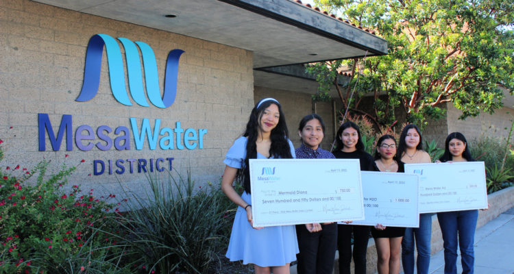 Students holding check posters
