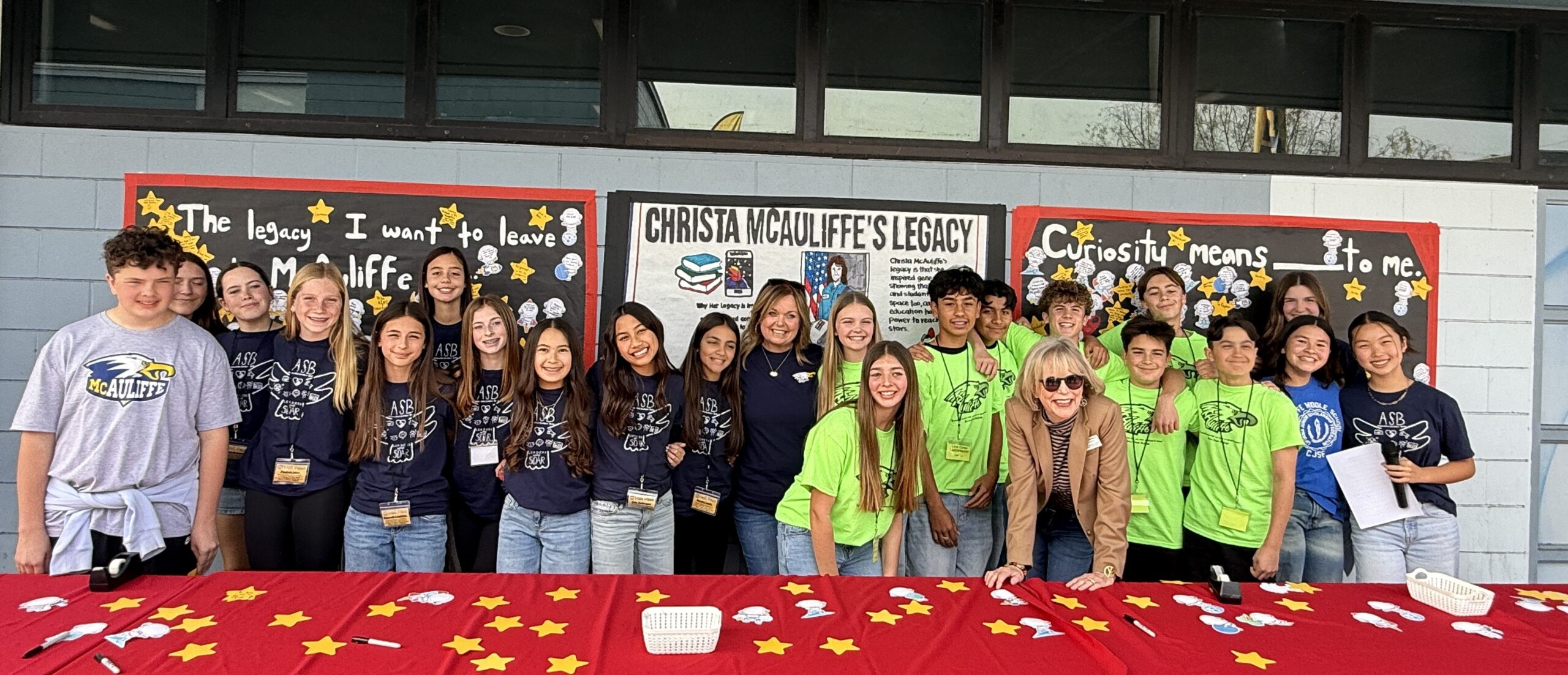 Students and staff at McAuliffe Middle School stand together in front of student-created legacy displays during a campus observance honoring Christa McAuliffe.