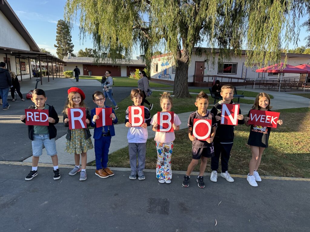 Students holding sign that says "Red Ribbon Week"