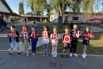 Students holding sign that says "Red Ribbon Week"