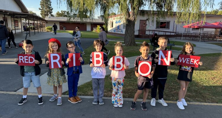 Students holding sign that says "Red Ribbon Week"