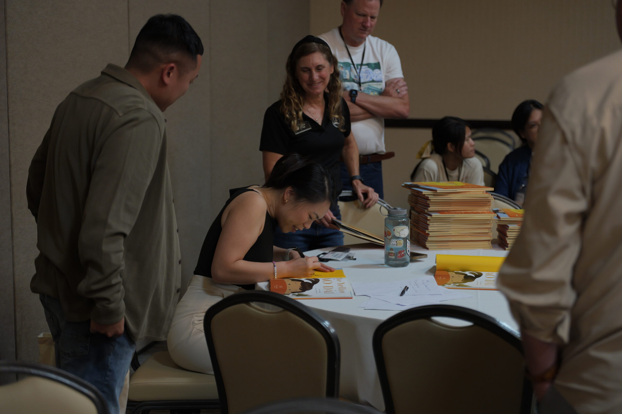 Julie Hull, coordinator of OCDE’s GATE and National History Day programs, smiles as she waits to have her copy of “The Yellow Áo Dài” signed by illustrator Minnie Phan.