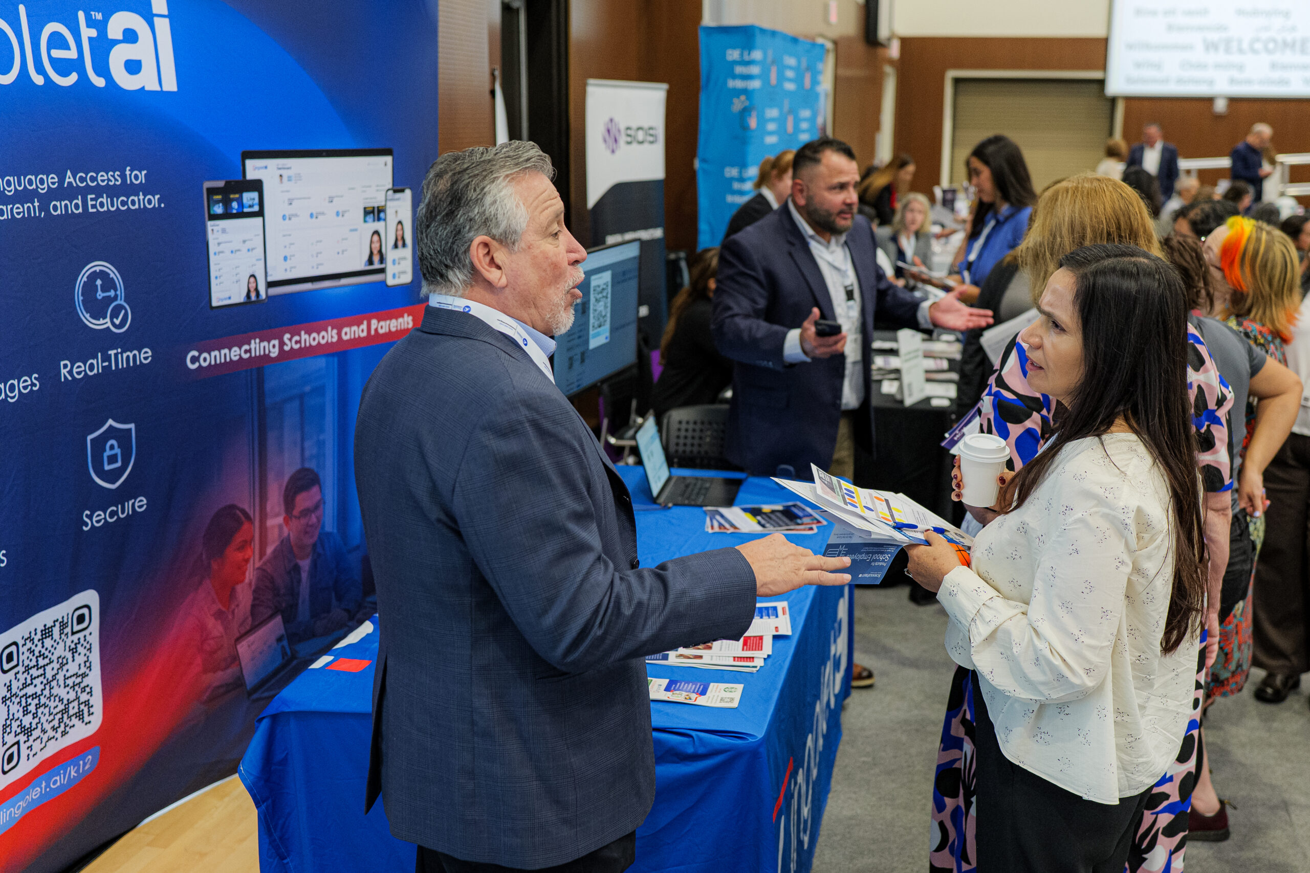 Conference attendees speak with vendors between sessions at Vanguard University.
