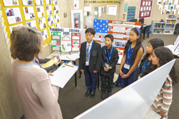 Students, wearing their medals, present their projects to judges for evaluation during the 2024 National History Day-Orange County competition.