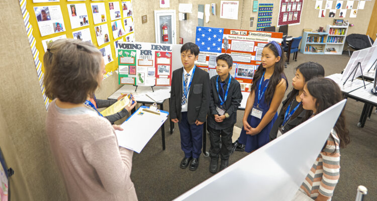 Students, wearing their medals, present their projects to judges for evaluation during the 2024 National History Day-Orange County competition.